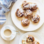 pillsbury air fryer cinnamon rolls on a plate next to coffee and a napkin