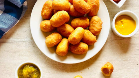 air fryer mini corn dogs on a plate next to ketchup and mustard