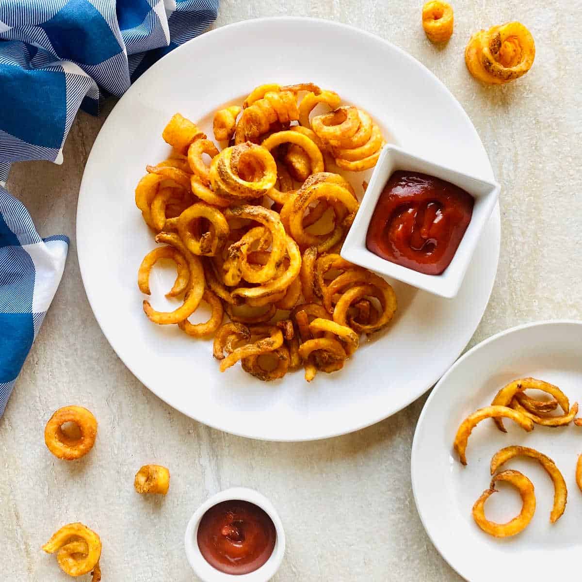 curly fries air fryer on a plate next to ketchup