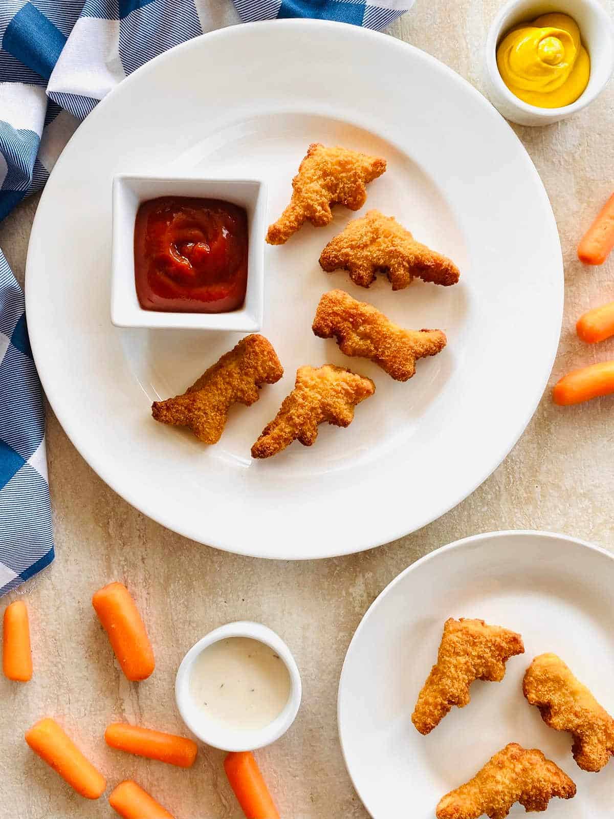 dino nuggets air fryer on a plate with carrots and dipping sauce