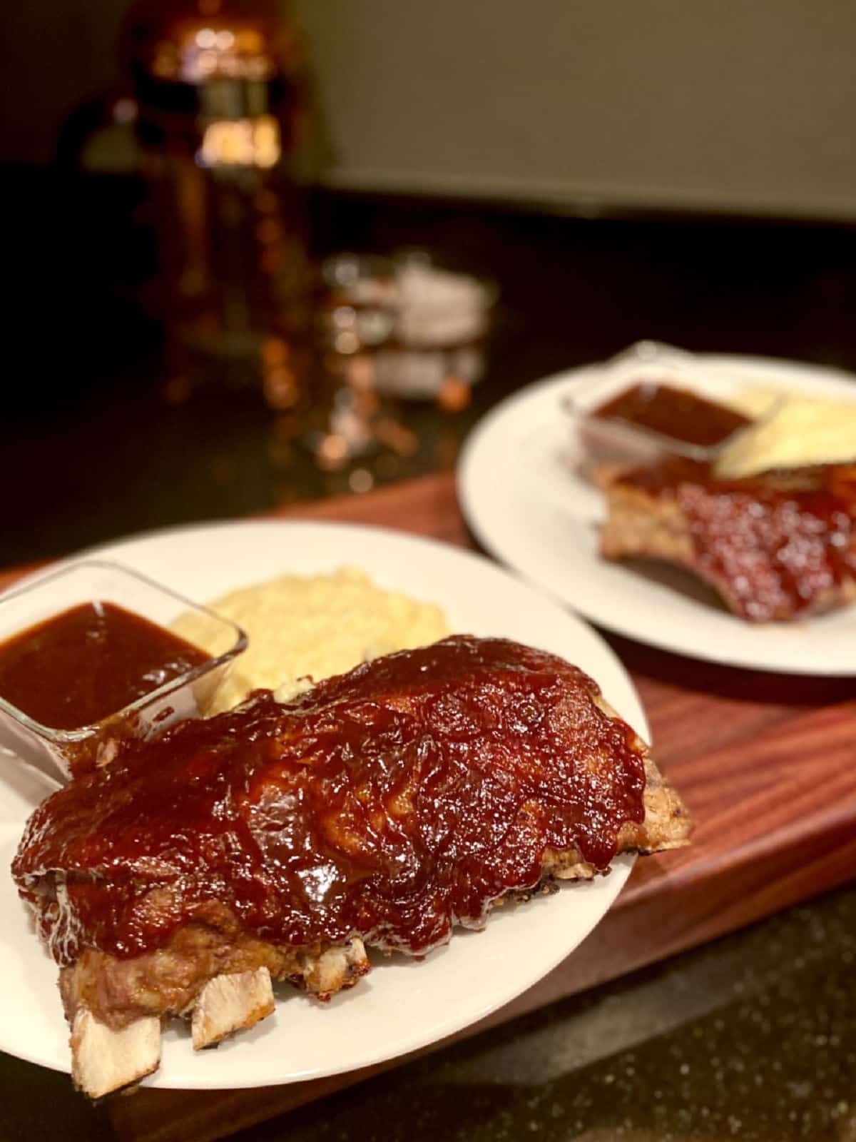 air fryer reheat ribs on a plate with a side of barbeque sauce and polenta