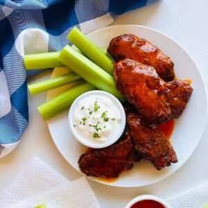 wings reheated in air fryer on plate with blue cheese and celery sticks