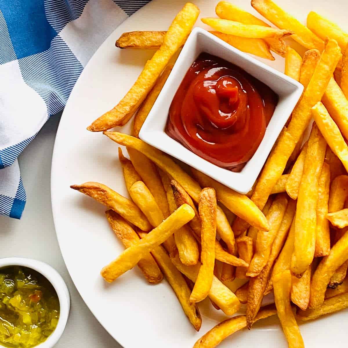reheated fries in air fryer next to ketchup and relish