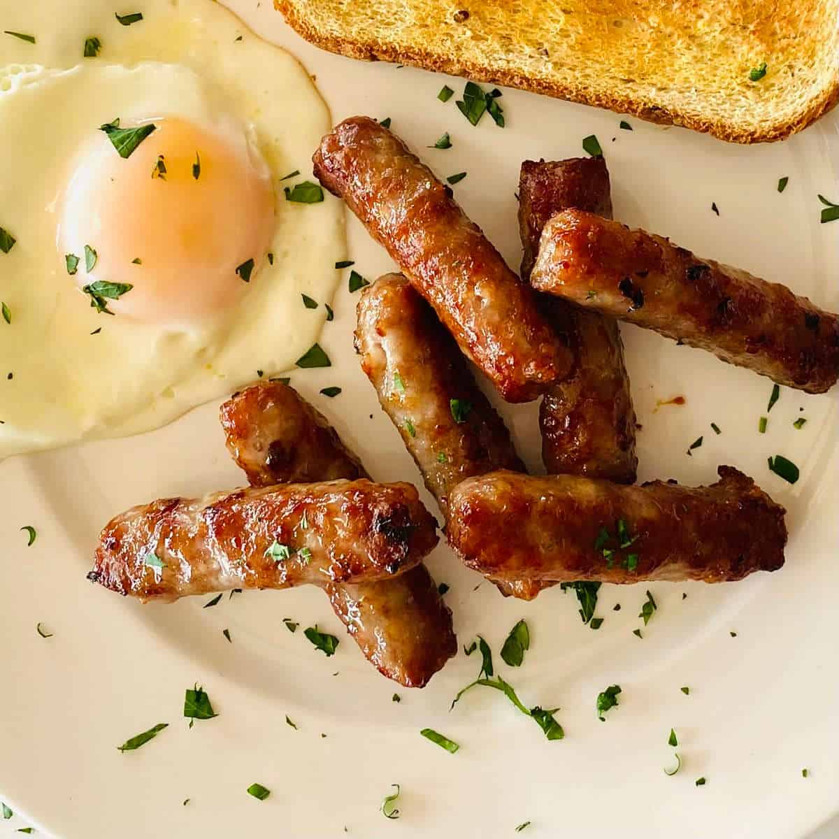 breakfast sausage cooked in air fryer on plate with eggs