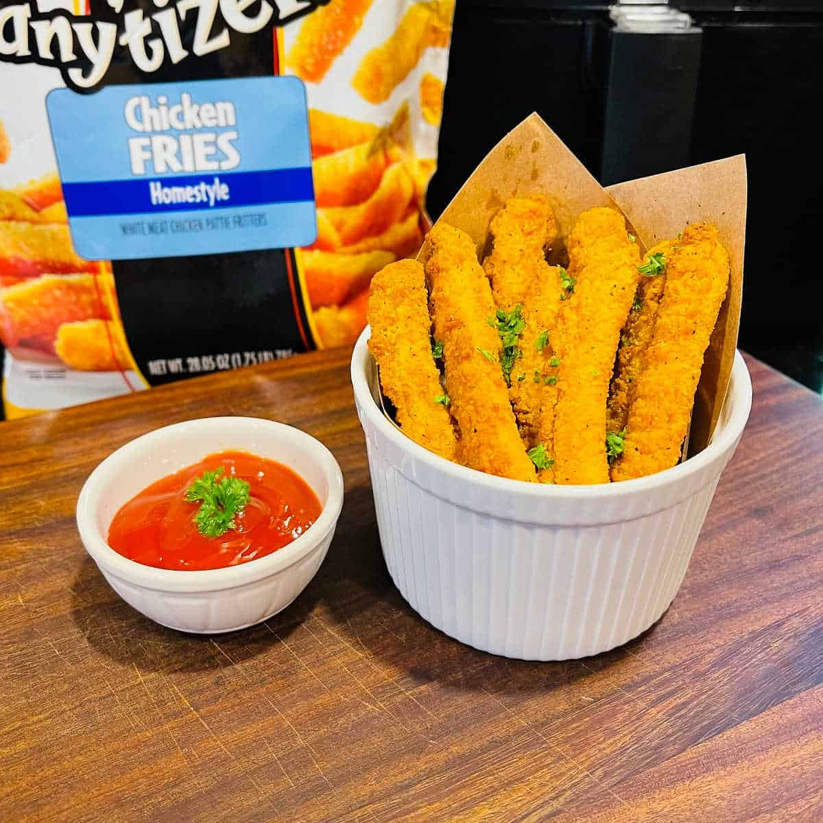 air fryer chicken fries in a bowl with marinara sauce