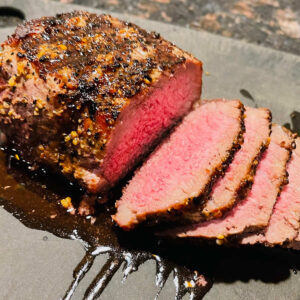 air fryer top sirloin steak sliced on cutting board.